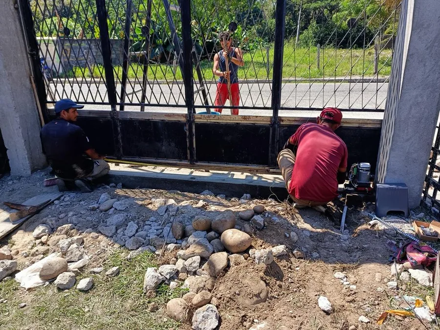 Técnicos instalando un portón eléctrico de reja