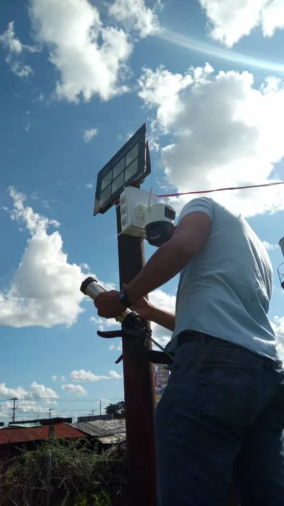 Instalador colocando una cámara en un poste